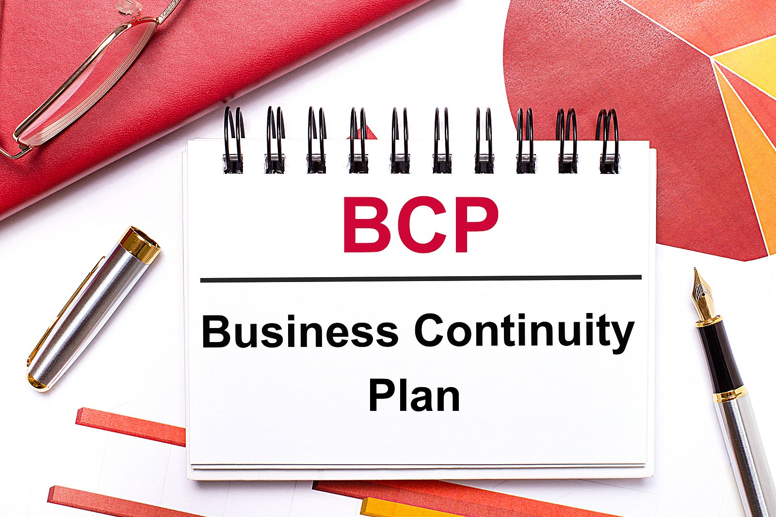 On The Desktop Is A White Notebook With The Text Bcp Business Co Business continuity planning session in progress